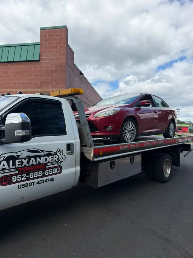 Red Ford Focus on a flatbed tow truck in the Twin Cities