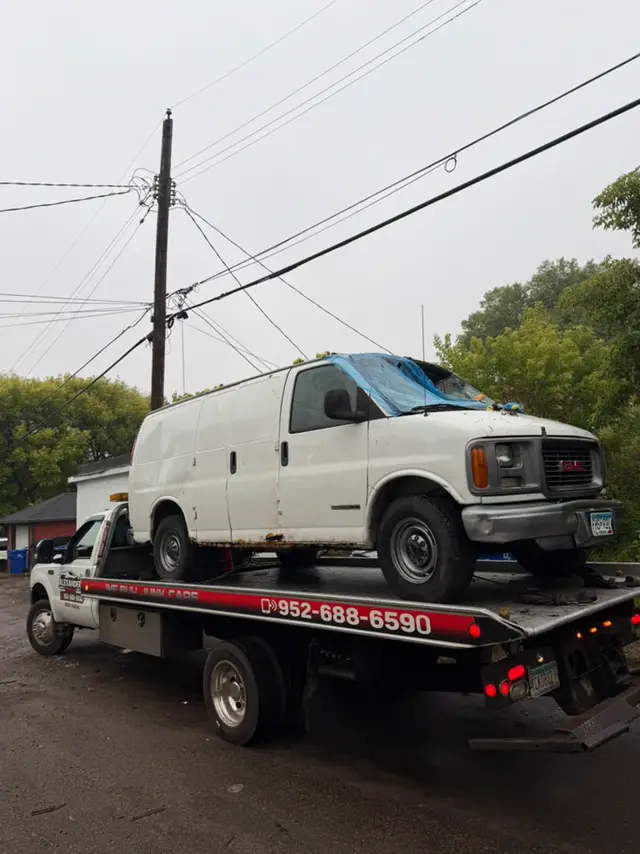 GMC cargo van on a flatbed tow truck in Minnesota