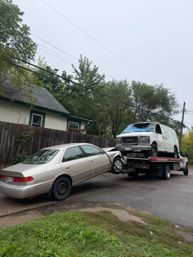 Cargo van on the flatbed and a sedan hooked behind in the Twin Cities