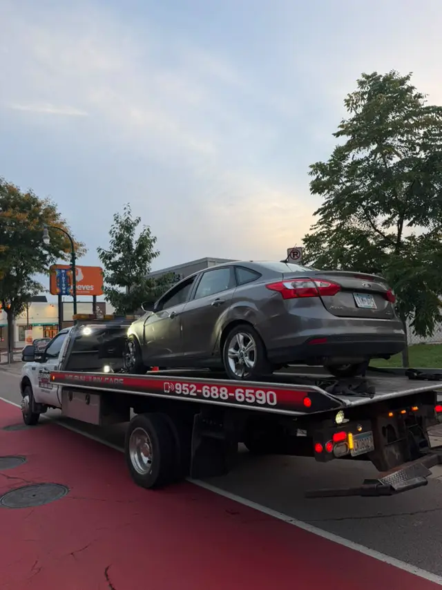 Sedan towed at dusk in the Twin Cities
