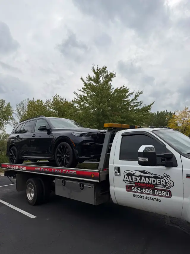 BMW X7 transportada en grúa de plataforma en los Twin Cities